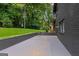 Features a large, grey concrete patio with a retaining wall and grassy area at 1239 Teakwood Trl, Stone Mountain, GA 30083