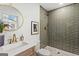 Bathroom featuring glass-enclosed shower with unique tile, round mirror and vanity with gold faucet at 1239 Teakwood Trl, Stone Mountain, GA 30083