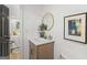 Elegant powder room boasting a round mirror, gold faucet, and a chic, framed art print at 1239 Teakwood Trl, Stone Mountain, GA 30083