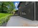Black brick exterior with a concrete patio and landscaped yard at 1239 Teakwood Trl, Stone Mountain, GA 30083