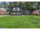 Two-story home with dark gray brick exterior, wood shutters, and green lawn at 1239 Teakwood Trl, Stone Mountain, GA 30083