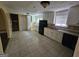 Well-lit kitchen with black appliances, white cabinets, and tiled floors at 2670 Foxlair Trl, South Fulton, GA 30349