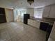 Well-lit kitchen with black appliances, white cabinets, and tiled floors at 2670 Foxlair Trl, South Fulton, GA 30349