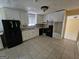 Functional kitchen features white cabinetry, tile floors, and black appliances at 2670 Foxlair Trl, South Fulton, GA 30349