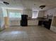 Functional kitchen features white cabinetry, tile floors, and black appliances at 2670 Foxlair Trl, South Fulton, GA 30349