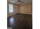 Living room with dark vinyl wood flooring, a bright window, ceiling fan, and direct access to the front door at 2670 Foxlair Trl, South Fulton, GA 30349