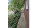 Landscaped side yard with lush greenery and a paved walkway along the brick house at 2670 Foxlair Trl, South Fulton, GA 30349
