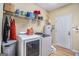 Bright laundry room with new washer and dryer and ample shelving for storage and a light wood floor at 2928 Mandy Ct, Jonesboro, GA 30236