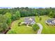 Expansive estate on lush grounds with mature trees, circular driveway, and craftsman-style home with stone accents at 55 Jolie Ln, Sharpsburg, GA 30277