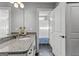 Granite-topped vanity features plenty of counter space and white cabinetry next to an adjacent open bathroom at 55 Jolie Ln, Sharpsburg, GA 30277