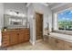 Bathroom with double sink vanity, tiled shower, and soaking tub under a large window at 55 Jolie Ln, Sharpsburg, GA 30277