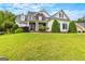 Picture-perfect home featuring stone accents, dark shutters, neatly trimmed landscaping, and a lush green lawn at 55 Jolie Ln, Sharpsburg, GA 30277