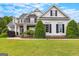 Charming home with stone accents, dark shutters, perfectly trimmed landscaping, and vibrant green lawn at 55 Jolie Ln, Sharpsburg, GA 30277