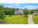 Craftsman-style home on a large lot, featuring a manicured lawn, mature trees, and a circular driveway at 55 Jolie Ln, Sharpsburg, GA 30277