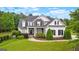 Two-story craftsman house with stone accents, dark shutters, manicured landscaping, and expansive green lawn at 55 Jolie Ln, Sharpsburg, GA 30277