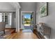 Bright foyer with hardwood floors, traditional moldings, view of the front yard, and decorative console table at 55 Jolie Ln, Sharpsburg, GA 30277