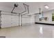 Bright and spacious three-car garage with white doors, epoxy flooring, and well-lit interiors at 55 Jolie Ln, Sharpsburg, GA 30277
