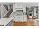 Bright kitchen features white cabinetry, stainless steel appliances, and hardwood floors at 55 Jolie Ln, Sharpsburg, GA 30277