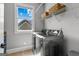 Laundry room with modern appliances, storage shelves, and a bright window view at 55 Jolie Ln, Sharpsburg, GA 30277