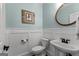 Cozy half bathroom with wainscoting and decorative mirror at 55 Jolie Ln, Sharpsburg, GA 30277
