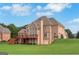 Expansive brick home with deck overlooking a lush green lawn and wooded area at 413 Canterbury Way, Jonesboro, GA 30236