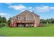 Beautiful backyard view of a brick home with deck and mature landscaping at 413 Canterbury Way, Jonesboro, GA 30236