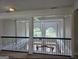 Second story landing with decorative railing overlooks a light-filled living space and beautiful scenery at 413 Canterbury Way, Jonesboro, GA 30236