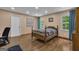 Comfortable bedroom featuring hardwood floors, natural light from two windows, and blue curtains at 190 Willow Lake Ln, Sharpsburg, GA 30277