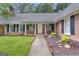 Charming front entrance with a brick facade, black shutters, and a welcoming white door framed by manicured landscaping at 190 Willow Lake Ln, Sharpsburg, GA 30277