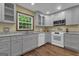 Well-lit kitchen with modern appliances, including a dishwasher, microwave, and stove, complemented by hardwood floors at 190 Willow Lake Ln, Sharpsburg, GA 30277