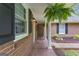Covered side porch featuring a patterned brick floor, white columns, hanging ferns, and brick exterior at 190 Willow Lake Ln, Sharpsburg, GA 30277