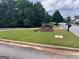 Landscaped entrance sign for Brentwood Park Clubhouse surrounded by green grass and mature trees at 149 Titan Rd, Stockbridge, GA 30281