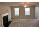 Bright living room featuring a fireplace, carpet, two windows and an open floor plan at 149 Titan Rd, Stockbridge, GA 30281