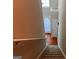 Carpeted stairway with a view of the front door and hardwood floors at 149 Titan Rd, Stockbridge, GA 30281