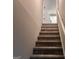 Carpeted stairway leading to an upper level with a visible doorway and railing at 149 Titan Rd, Stockbridge, GA 30281