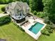 Aerial view of a home with a pool, patio, and lush landscaping at 2975 Hickory Hill Rd, Brooks, GA 30205