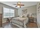 Comfortable bedroom featuring a metal bed frame, ceiling fan, and a sunlit window at 2975 Hickory Hill Rd, Brooks, GA 30205
