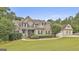 Charming two-story home featuring a manicured lawn, stone accents, and a detached garage at 2975 Hickory Hill Rd, Brooks, GA 30205