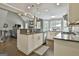 Spacious kitchen boasts large island, stainless steel appliances, modern lighting, and dark wood floors at 2975 Hickory Hill Rd, Brooks, GA 30205