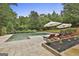 Beautiful pool area with lounge chairs, umbrellas, and well-manicured landscaping at 2975 Hickory Hill Rd, Brooks, GA 30205