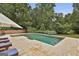 Backyard swimming pool surrounded by patio and mature trees at 2975 Hickory Hill Rd, Brooks, GA 30205
