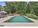 Backyard swimming pool surrounded by patio, greenery, and mature trees at 2975 Hickory Hill Rd, Brooks, GA 30205