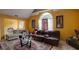 Vaulted ceiling living room with yellow walls, fireplace, and lots of seating space, with large windows for plenty of light at 7101 Brecken Pl, Lithonia, GA 30058