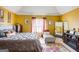 Spacious main bedroom with yellow walls, a large bed, and natural light, creating a bright and airy retreat at 7101 Brecken Pl, Lithonia, GA 30058