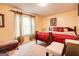 Cozy bedroom featuring a comfortable red bed, warm-toned walls and three art pictures, creating a relaxing retreat at 7101 Brecken Pl, Lithonia, GA 30058