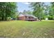 Grassy backyard featuring a brick home with a wooden deck at 602 Pine Knoll Court, Mcdonough, GA 30252