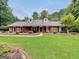 Charming brick home with a well-manicured lawn, dormer windows, and inviting front porch swing at 602 Pine Knoll Court, Mcdonough, GA 30252