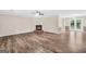 Spacious living room with wood floors, brick fireplace, and access to the outdoor patio at 602 Pine Knoll Court, Mcdonough, GA 30252