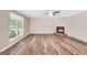 Cozy living room with wood floors, a brick fireplace, and bright natural lighting at 602 Pine Knoll Court, Mcdonough, GA 30252
