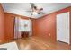 This bedroom features hardwood floors, a ceiling fan, and a bright window, offering a serene and comfortable space at 7972 Woods Lane, Jonesboro, GA 30236